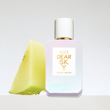 Dear Sky 50ml white bottle with sliced melon on grey background.