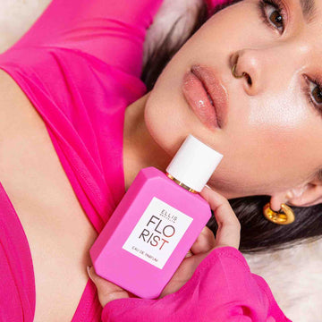 Model with brown hair and pink dress holding Florist 50ml bottle.