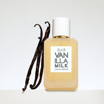 Vanilla Milk 50ml bottle with white cap and three vanilla beans on grey background.