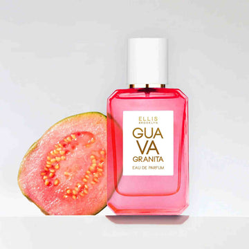Guava Granita 50ml pink bottle and sliced Guava on a grey background.