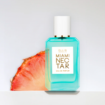 Miami Nectar 50ml Eau De Parfum with sliced pink pineapple on grey background.