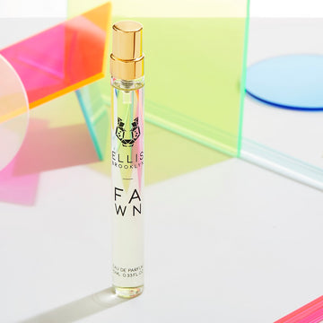 Fawn 10ml Eau De Parfum Travel Spray on white table with multiple, coloful, circle and square prismatic props, on white background.