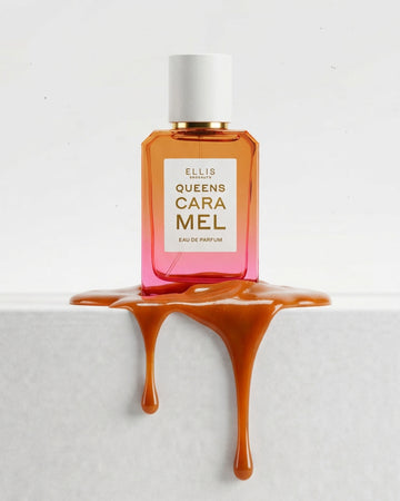 QUEENS CARAMEL eau de parfum 50mL bottle with a white cap, set on a white surface with caramel-colored liquid dripping from the base.