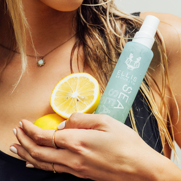 IMAGE 3: MODEL HOLDING SEA FRAGRANCE AND BODY MIST AND LEMONS