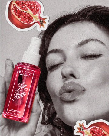Black and white image of a woman holding LOVE POM Perfume Mist 90ml without cap and making a kissing face overlaid with drawn images of sliced red pomegranates outlined in white
