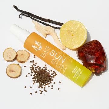 Brume parfumée pour cheveux et corps Sun 100ml sur fond blanc avec gousse de vanille, bois de cèdre, citron, morceau d'ambre et graines.