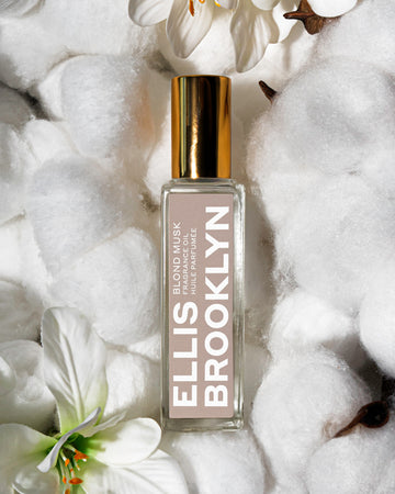 Blond Musk Fragrance Oil 15ml resting on cotton and white flowers.