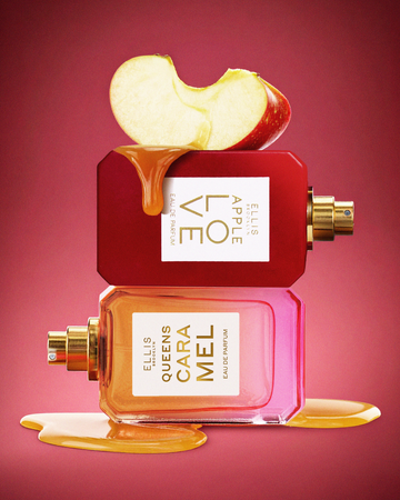 Sliced red apple on top of Apple Love 50ml Eau De Parfum without cap, on top of Queens Caramel 50ml Eau De Parfum without cap in melted caramel, on red background.