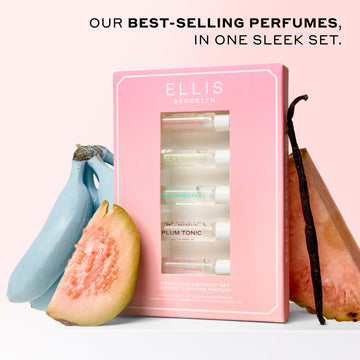 Best Sellers Discovery Set between blue bananas, slice of guava, vanilla bean, and slice of pink pineapple on a white surface with a pink background with black text that reads "Our best-selling perfumes, in one sleek set."