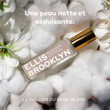 Huile parfumée Blond Musk (15 ml) posée sur du coton et des fleurs blanches, entre les mots « Une peau nette et séduisante » et « Le paradis du musc blanc » inscrits en blanc.