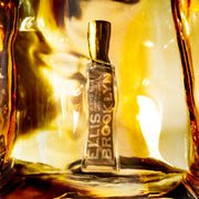 Huile parfumée Blond Musk (15 ml) placée derrière un bloc d'ambre.