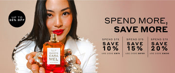 Model with brown hair wearing white jacket with pearls on sleeves holding Queens Caramel 50ml Eau De Parfum without cap and silver ornaments in two hands, on light brown background with black text that reads "Spend More, Save More Spend $75, Save 10% Use Code EB75 Spend $150, Save $15 Use Code EB150 Spend $250, Save 20% Use Code EB250" and black circle with white text that reads "Up To 20% Off"