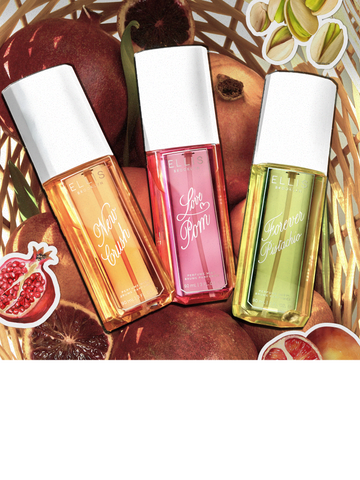 NEW CRUSH Perfume Mist 90ml, LOVE POM Perfume Mist 90ml, and FOREVER PISTACHIO Perfume Mist 90ml in tan basket filled with pomegranates and blood oranges