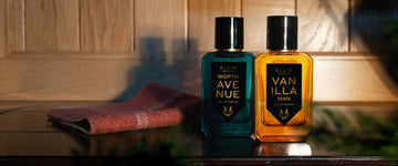 Worth Avenue 50ml Eau De Parfum and Vanilla Man 50ml Eau De Parfum resting on wood shelf next to fabric, with wood paneling in background.