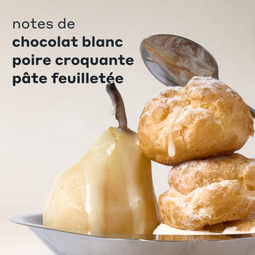 Notes de parfum COCOA BLANCO présentées avec une poire nappée de chocolat blanc et deux pâtisseries feuilletées saupoudrées sur un plateau en argent, avec une cuillère derrière elles et du texte noir qui dit « notes de chocolat blanc, poire croquante, pâte feuilletée » sur un fond crème.
