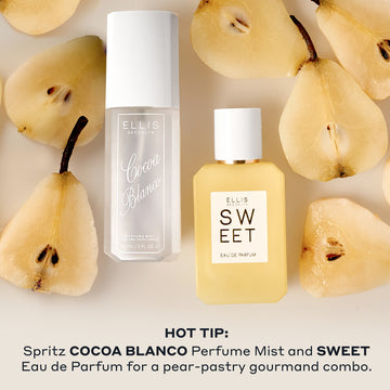 A white frosted COCOA BLANCO 90ml Perfume Mist bottle and a yellow SWEET 50ml Eau de Parfum bottle arranged next to each other on a light neutral background with sliced pear pieces around them with text at the bottom reading "HOT TIP: Spritz COCOA BLANCO Perfume Mist and SWEET Eau de Parfum for a pear-pastry gourmand combo."