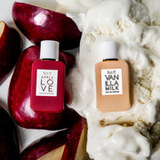 Apple Love 7.5ml Eau De Parfum Mini Dabber on sliced apples next to Vanilla Milk 7.5ml Eau De Parfum Mini Dabber on vanilla ice cream, on white background.