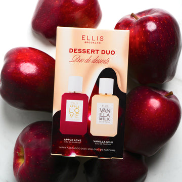 Dessert Duo box resting on red apples on white background.