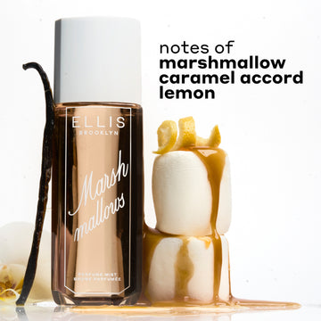 MARSHMALLOWS Perfume Mist 240ml between 2 stacked marshmallows covered in dripping caramel and topped with a lemon peel and a vanilla bean and flower leaning against the bottle on a white background with black text that reads "notes of marshmallow, caramel accord, lemon"
