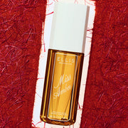 Flacon de 90 mL de brume parfumée Miss Amber encadré par un fond rouge texturé.