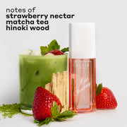 MISS STRAWBERRY Perfume Mist 90ml next to matcha powder, two strawberries, hinoki wood, and a glass cup filled with ice, matcha tea, and a strawberry with black text that reads "notes of strawberry nectar, matcha tea, hinoki wood" on a white background