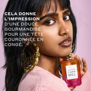 Femme aux cheveux noirs portant un pull rose et des boucles d'oreilles créoles en or qui disent 