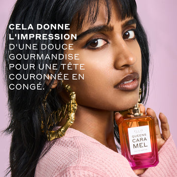 Femme aux cheveux noirs portant un pull rose et des boucles d'oreilles créoles en or qui disent 