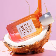 QUEENS CARAMEL Eau de Parfum 50ml laying in half of a coconut with caramel dripping on the bottle on pink background