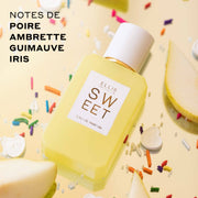 Eau de Parfum Sweet 50ml et spray de voyage Eau de Parfum Sweet 10ml sur fond jaune avec des vermicelles arc-en-ciel, des bonbons cœur blancs et des poires tranchées avec un texte noir qui dit « notes de poire, ambrette guimauve, Iris »
