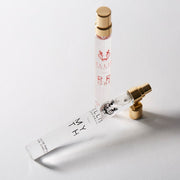 Vaporisateur de voyage Myth 10 ml Eau de Parfum avec le bouchon retiré à côté du vaporisateur de voyage Rrose 10 ml Eau de Parfum sur fond blanc.