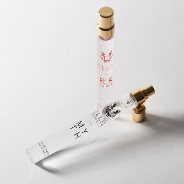 Vaporisateur de voyage Myth 10 ml Eau de Parfum avec le bouchon retiré à côté du vaporisateur de voyage Rrose 10 ml Eau de Parfum sur fond blanc.