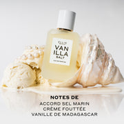 Vanilla Salt 50 ml Eau de Parfum posé sur un coquillage blanc dans de la glace à la vanille fondue à côté de boules de glace à la vanille et de perles sur fond blanc au-dessus d’un texte noir qui dit « Notes de accord sel marin, crème fouettée, vanille de Madagascar ».