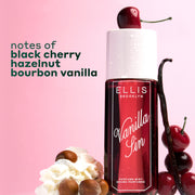 VANILLA SIN Perfume Mist 240ml topped with a cherry and between 4 stacked cherries, a vanilla bean leaning against the bottle and a pile of whipped cream with 4 hazelnuts on a pink and white ombré background with black text that reads "notes of black cherry, hazelnut, bourbon vanilla"