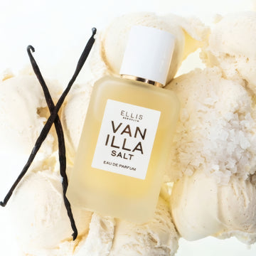 VANILLA SALT Eau de Parfum 50ml lays on scoops of vanilla ice cream, vanilla beans, and salt on a white background 