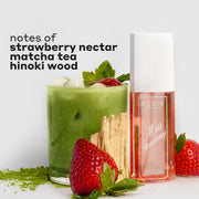 MISS STRAWBERRY Perfume Mist 90ml next to matcha powder, two strawberries, hinoki wood, and a glass cup filled with ice, matcha tea, and a strawberry with black text that reads "notes of strawberry nectar, matcha tea, hinoki wood" on a white background