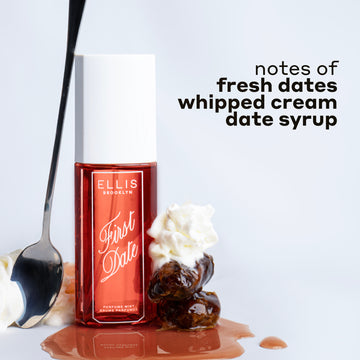 FIRST DATE Perfume Mist 90ml next to whipped cream, a spoon leaning against the bottle, a stack of 2 dates and whipped cream on date syrup with black text that reads "notes of fresh dates, whipped cream, date syrup" on a white background