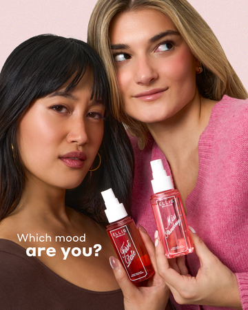 Woman with black hair wearing a brown shirt and gold hoop earrings holding FIRST DATE Perfume Mist 90ml next to a woman with blonde hair wearing a pink sweater holding MISS STRAWBERRRY Perfume Mist 90ml with white text that reads "Which mood are you?" on a white background