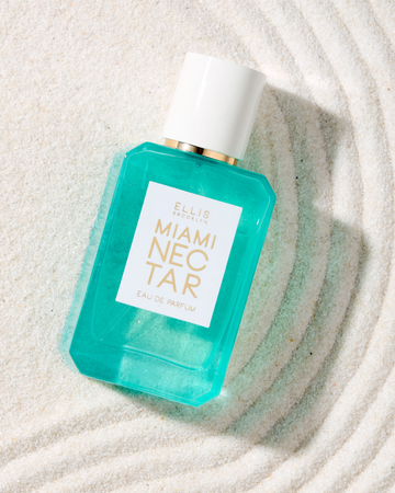 MIAMI NECTAR Eau de Parfum 50ml lays on white sand