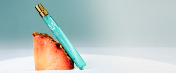 MIAMI NECTAR Eau de Parfum 10ml leans against a slice of pink pineapple on a gray background