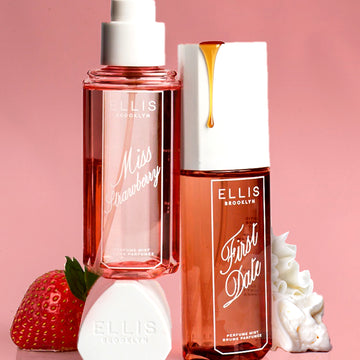 MISS STRAWBERRY Perfume Mist 90ml without cap sits on top of cap, next to FIRST DATE Perfume Mist 90ml with a drip of date syrup on the cap, next to a pile of whipped cream and a strawberry all on a pink background