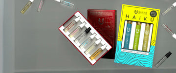 Mystery Fragrance Discovery Set box opened to show Apple Love 1.5ml Eau De Parfum Vial, Florist 1.5ml Eau De Parfum Vial, Salt 1.5ml Eau De Parfum Vial, Myth 1.5ml Eau De Parfum Vial, Vanilla Milk 1.5ml Eau De Parfum Vial and Sweet 1.5ml Eau De Parfum Vial next to Haiku Fragrance Rollerball Trio Box showing Salt 10ml Fragrance Rollerball, Sun Fruit 10ml Fragrance Rollerball, and Sweet 10ml Fragrance Rollerball on grey background surrounded by vials included in Mystery Fragrance Discovery Set.