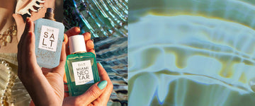 Hand holding Salt 50ml Eau De Parfum without cap with sand on bottle next to two hand with turquoise nail polish holding Miami Nectar 50ml Eau De Parfum, on collage background of abalone shells, white fabrics, shells, pearls, and model wearing gold charm necklace holding shell to face, to the left of up-close image of iridescent shell.