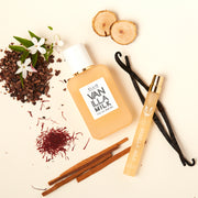 Vanilla Milk 50ml Eau de Parfum et Vanilla Milk 10ml Eau de Parfum spray de voyage sur fond blanc cassé avec des gousses de vanille, du bois de santal, des fleurs blanches et des coques de cacao.