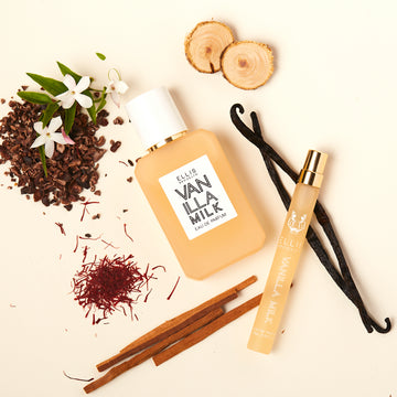 Vanilla Milk 50ml Eau de Parfum et Vanilla Milk 10ml Eau de Parfum spray de voyage sur fond blanc cassé avec des gousses de vanille, du bois de santal, des fleurs blanches et des coques de cacao.