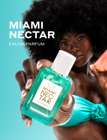 Woman with brown hair wearing a strapless teal bikini top and a French manicure holds MIAMI NECTAR Eau de Parfum out in front of her in one hand and a slice of pink pineapple in the other hand with white text that reads 'MIAMI NECTAR Eau de Parfum' on a teal background