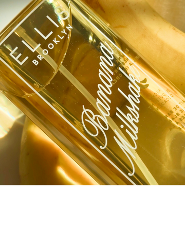 Close up of BANANA MILKSHAKE Perfume Mist 240ml sitting on yellow bananas