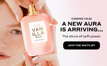 Woman with red hair and pale pink manicure holds VANILLA RICE Eau de Parfum 50ml without cap above her head with black text that reads "Coming 7.8.26. A new aura is arriving... The allure of soft power." and a black circle with white text that reads 'Join The Waitlist" all on a pink background