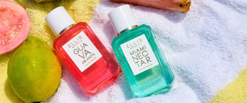 GUAVA GRANITA Eau de Parfum 50ml and MIAMI NECTAR Eau de Parfum 50ml lay down on a yellow and white striped towel with one whole guava, one half of a cut guava, and a slice of pink pineapple