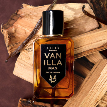 Vanilla Man 50ml Eau De Parfum on pieces of wood and vanilla beans, on brown background.