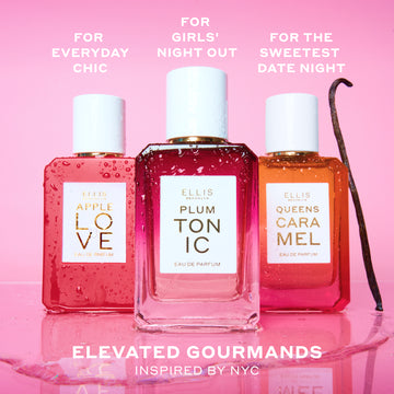 APPLE LOVE Eau de Parfum 50ml, PLUM TONIC Eau de Parfum 50ml, and QUEENS CARAMEL Eau de Parfum 50ml covered in water droplets next to vanilla bean and on top of water puddle on pink background with white text that reads "For Everyday Chic. For Girls' Night Out. For The Sweetest Date Night. Elevated Gourmands Inspired by NYC"